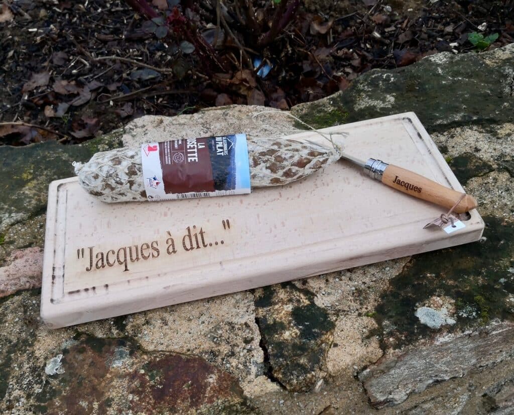 Planche apéritive personnalisée en bois avec texte gravé et couteau gravé.